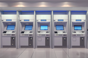 5台のATMが並んでいる銀行のイラスト。各ATMはディスプレイが点灯しており、シンプルで機能的なデザインが特徴です。背景は清潔感のある白と青の配色です。